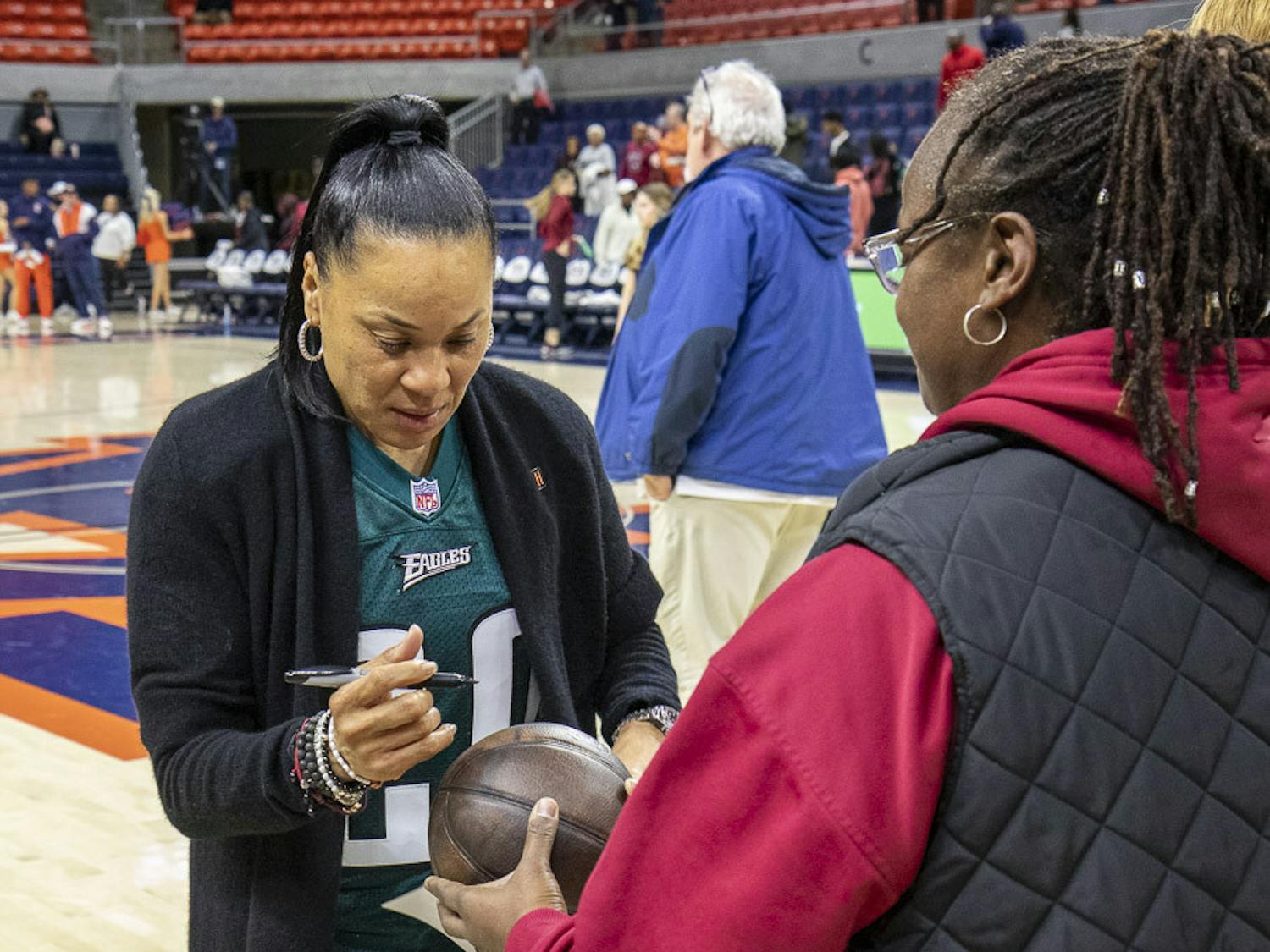 Head coach Dawn Staley signs a fan's basketball after the team's victory against Auburn on Feb. 9, 2023. This marks the Gamecocks' 30th win, setting a new program record.&nbsp;