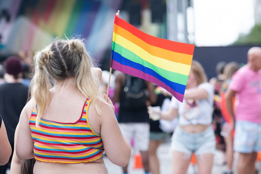 <p>An Outfest attendee waves a rainbow flag on June 4, 2022. Outfest featured performances, food and vendors in honor of Pride month.&nbsp;</p>