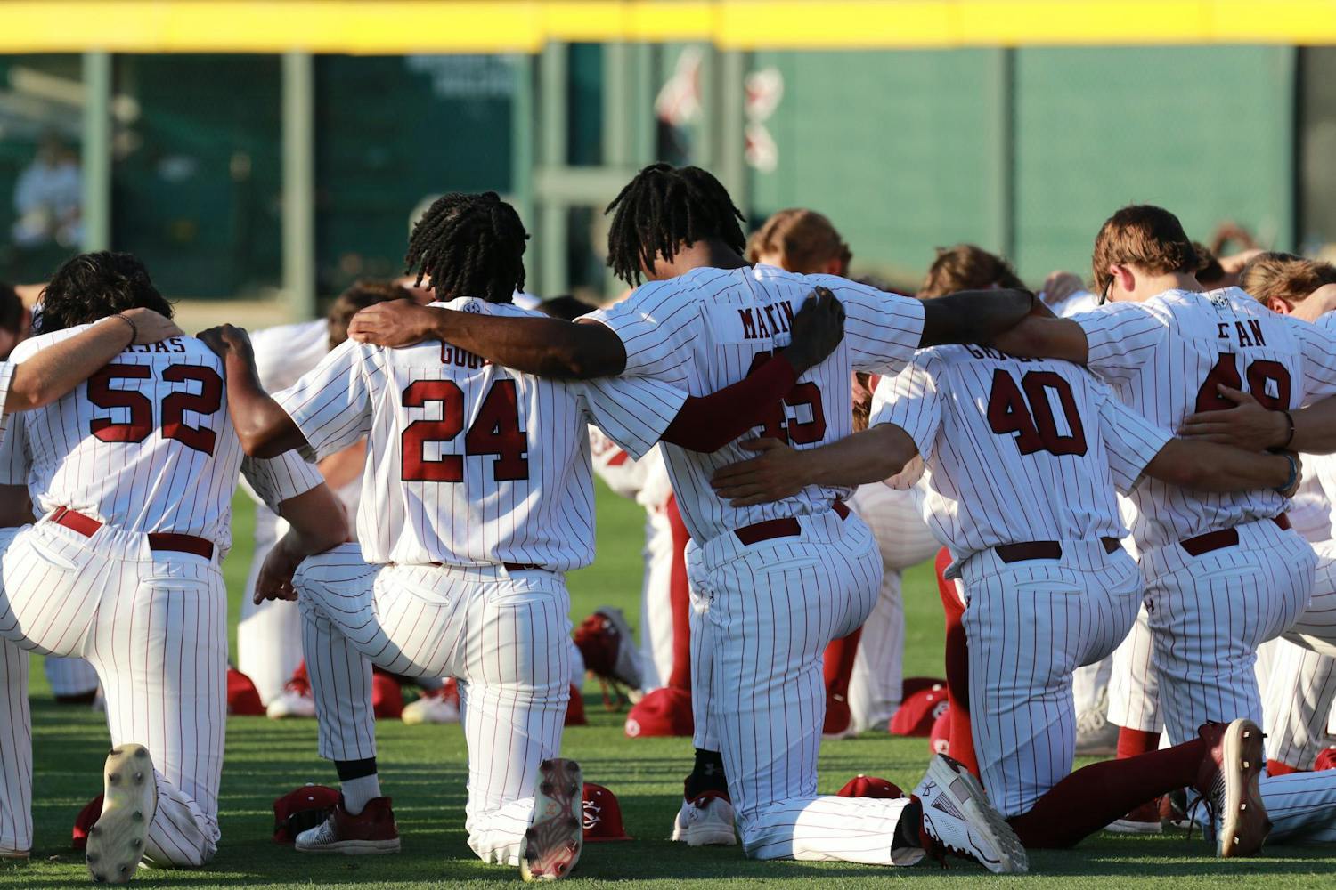 The Gamecocks kneel in a circle and pray as part of their pre-game ritual on April 19, 2024. The No. 20 South Carolina Gamecocks were defeated by the No. 2 Arkansas Razorbacks 2-1 in the first game of the weekend series.