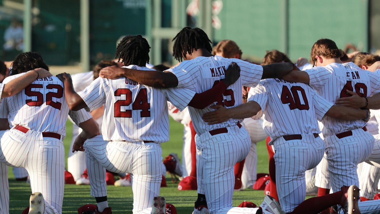 The Gamecocks kneel in a circle and pray as part of their pre-game ritual on April 19, 2024. The No. 20 South Carolina Gamecocks were defeated by the No. 2 Arkansas Razorbacks 2-1 in the first game of the weekend series.