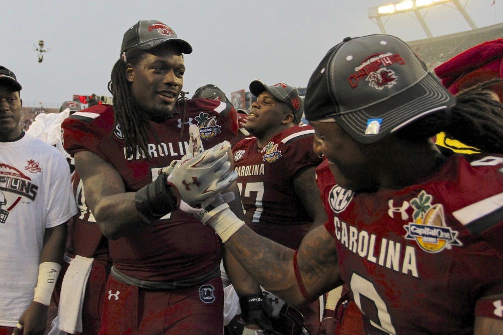 	Junior defensive end Jadeveon Clowney celebrates his last win at South Carolina with teammate Sharrod Golightly at the Capital One Bowl on Jan. 1.