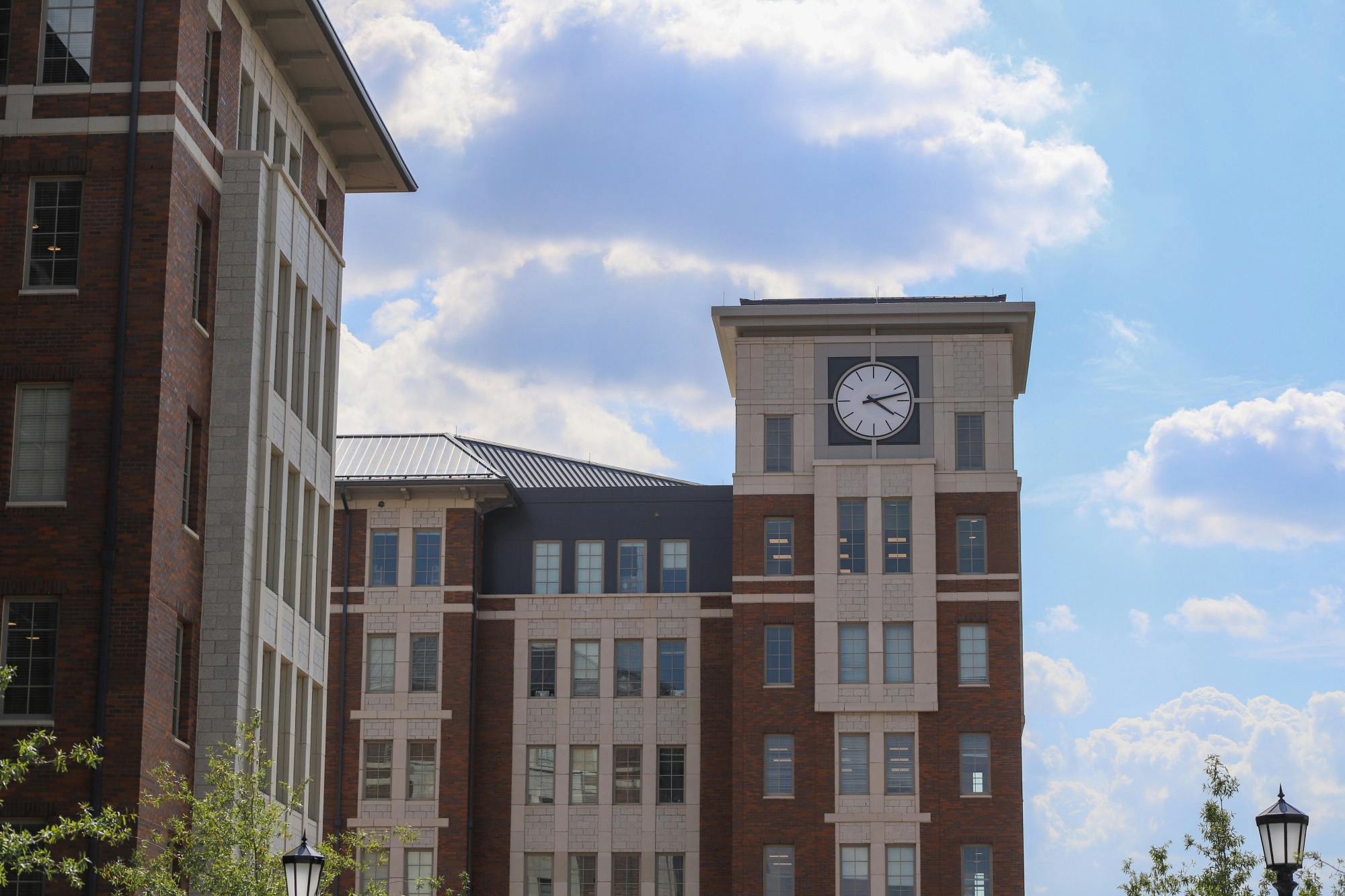 A picture of the clock tower on the top of Campus Village Building 1, the highest portion of the four new buildings. Each floor of the four new dorms holds a kitchen, private study space and community study space.