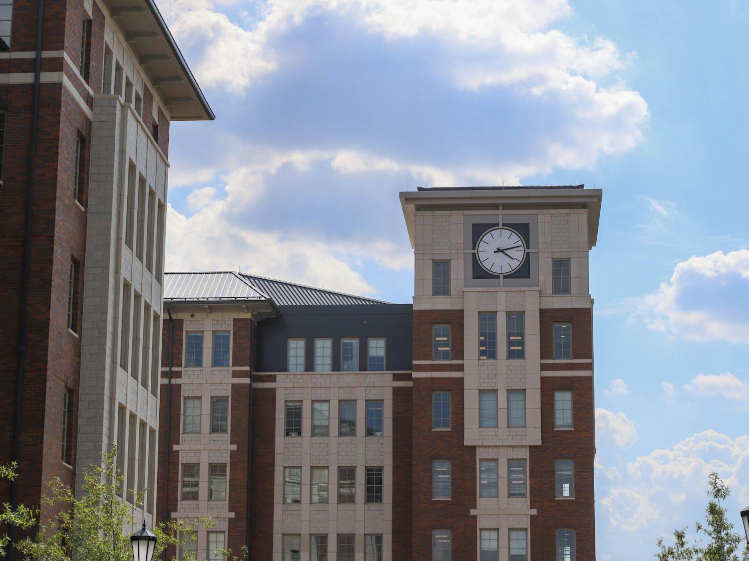 A picture of the clock tower on the top of Campus Village Building 1, the highest portion of the four new buildings. Each floor of the four new dorms holds a kitchen, private study space and community study space.