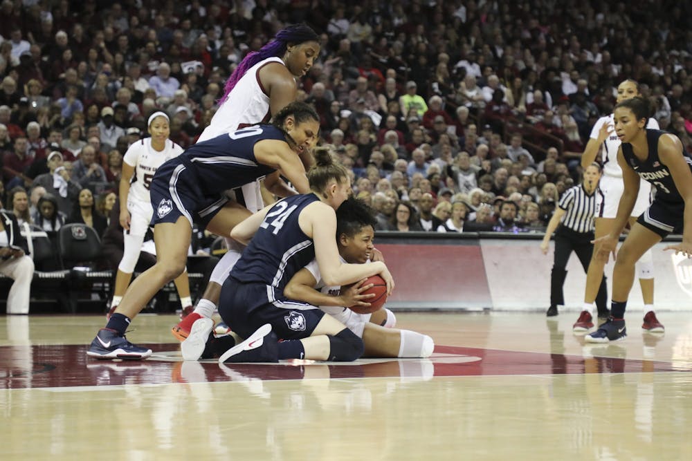 Freshman guard Zia Cooke attempts to keep the ball away from two UConn players. Cooke scored 15 points and had four rebounds against the Huskies.