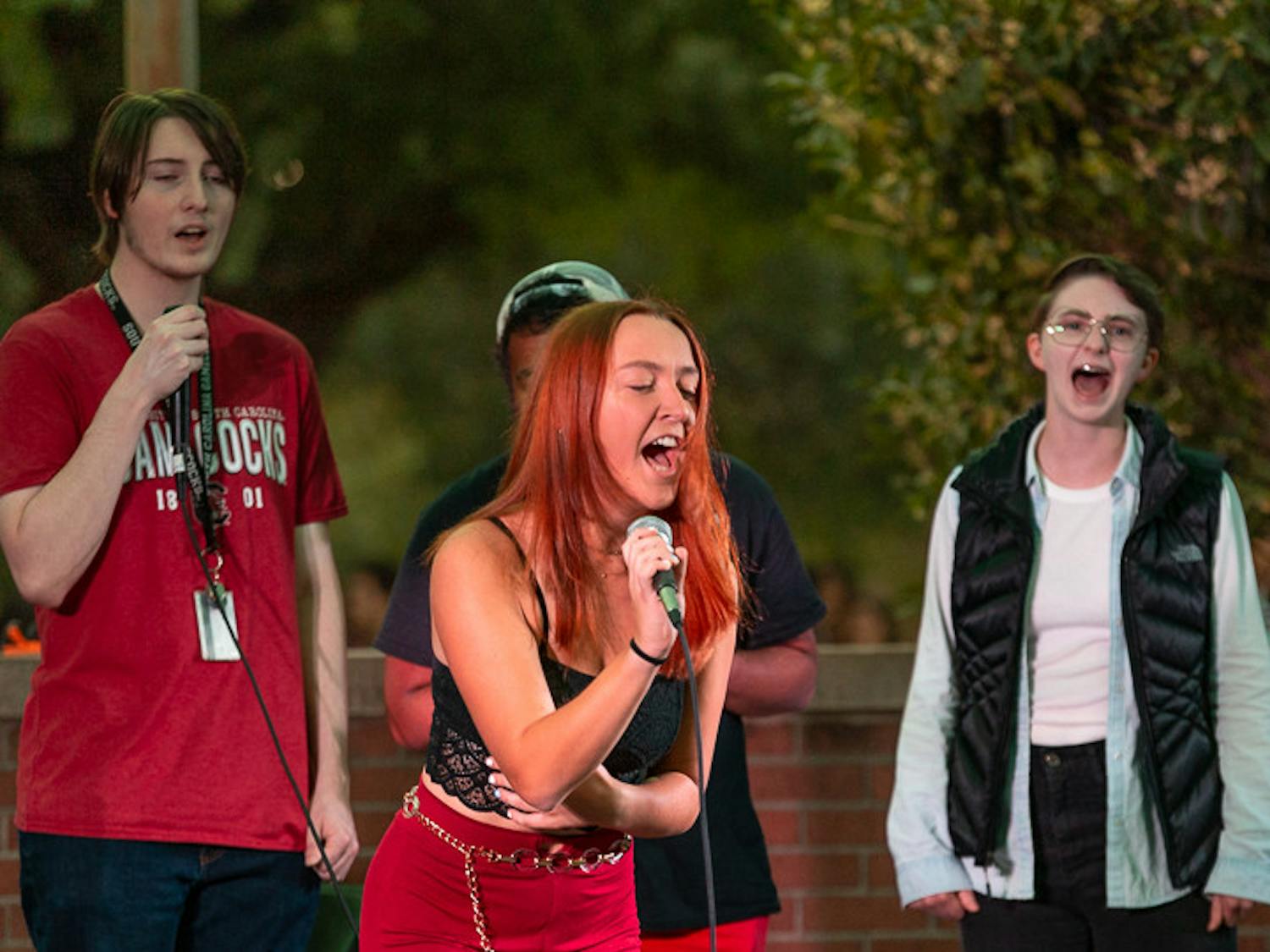 Third-year psychology student Erin McDonough sings with the background choir during The Resonance's performance at the USC Battle of the Bands on Oct. 5, 2022. The competition, brought acappella, folk, rap and rock music to the Russell House Patio in a variety of performances.