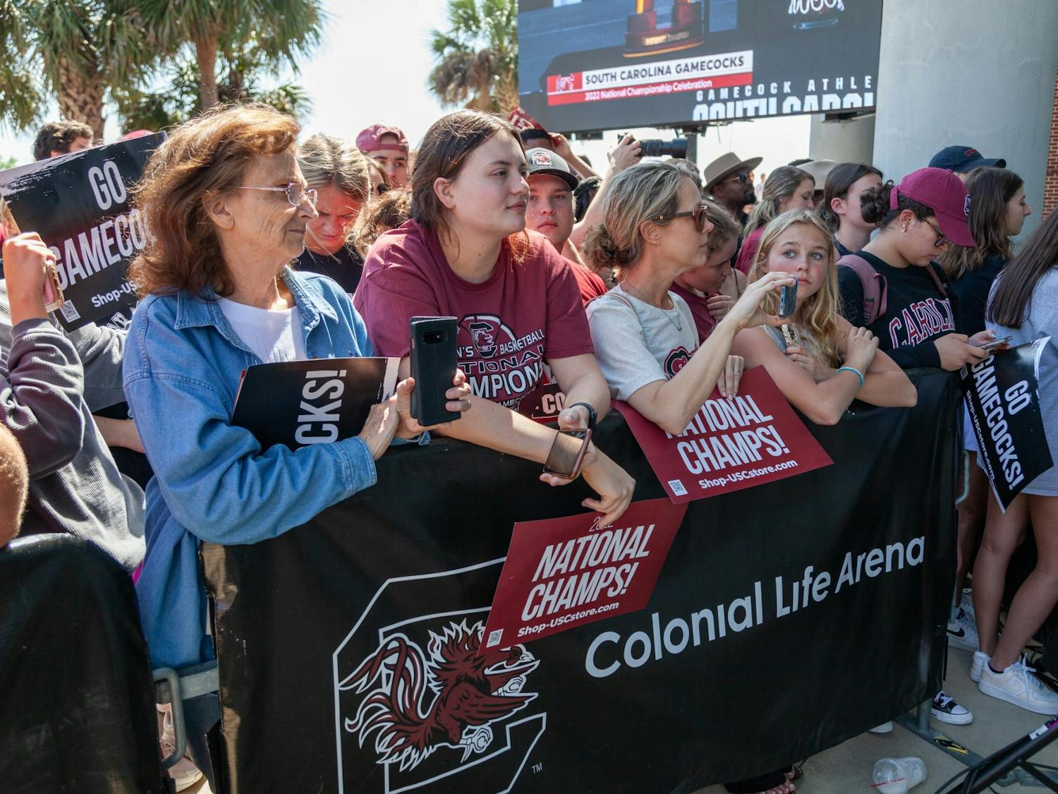 South Carolina fans take photos and hold signs at Colonial Life Arena in Columbia, SC on April 4, 2022. Fans waited for the team's arrival outside of the main entrance.