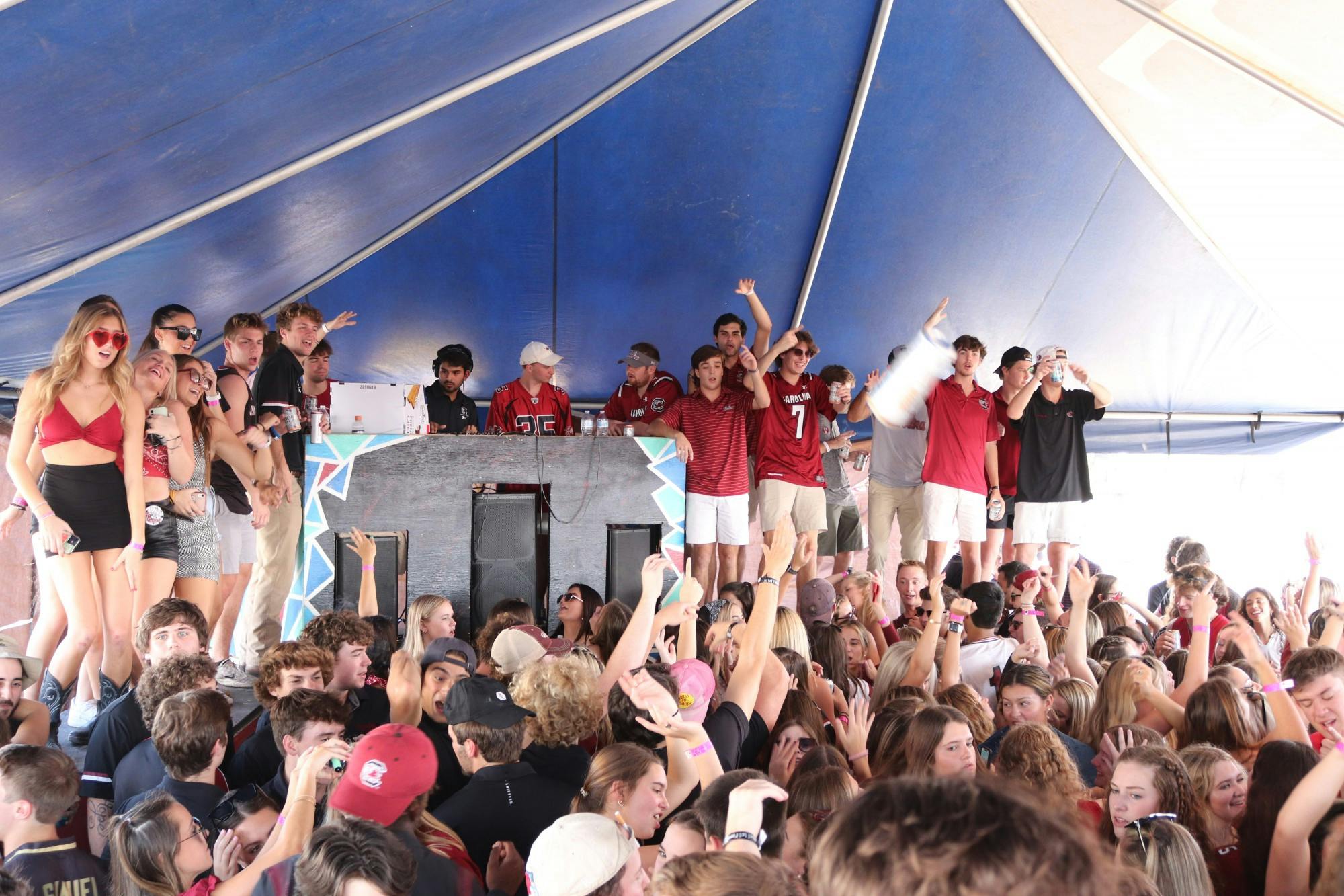 Students listen to music and dance while partying at the Fraternity Lots, a popular student tailgating event.