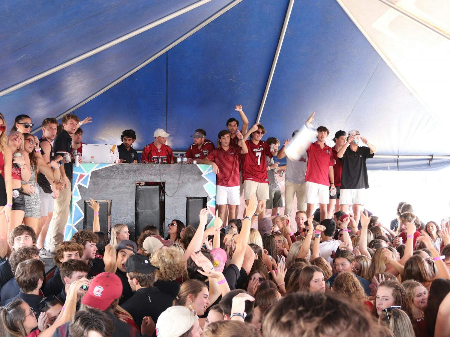 Students listen to music and dance while partying at the Fraternity Lots, a popular student tailgating event.