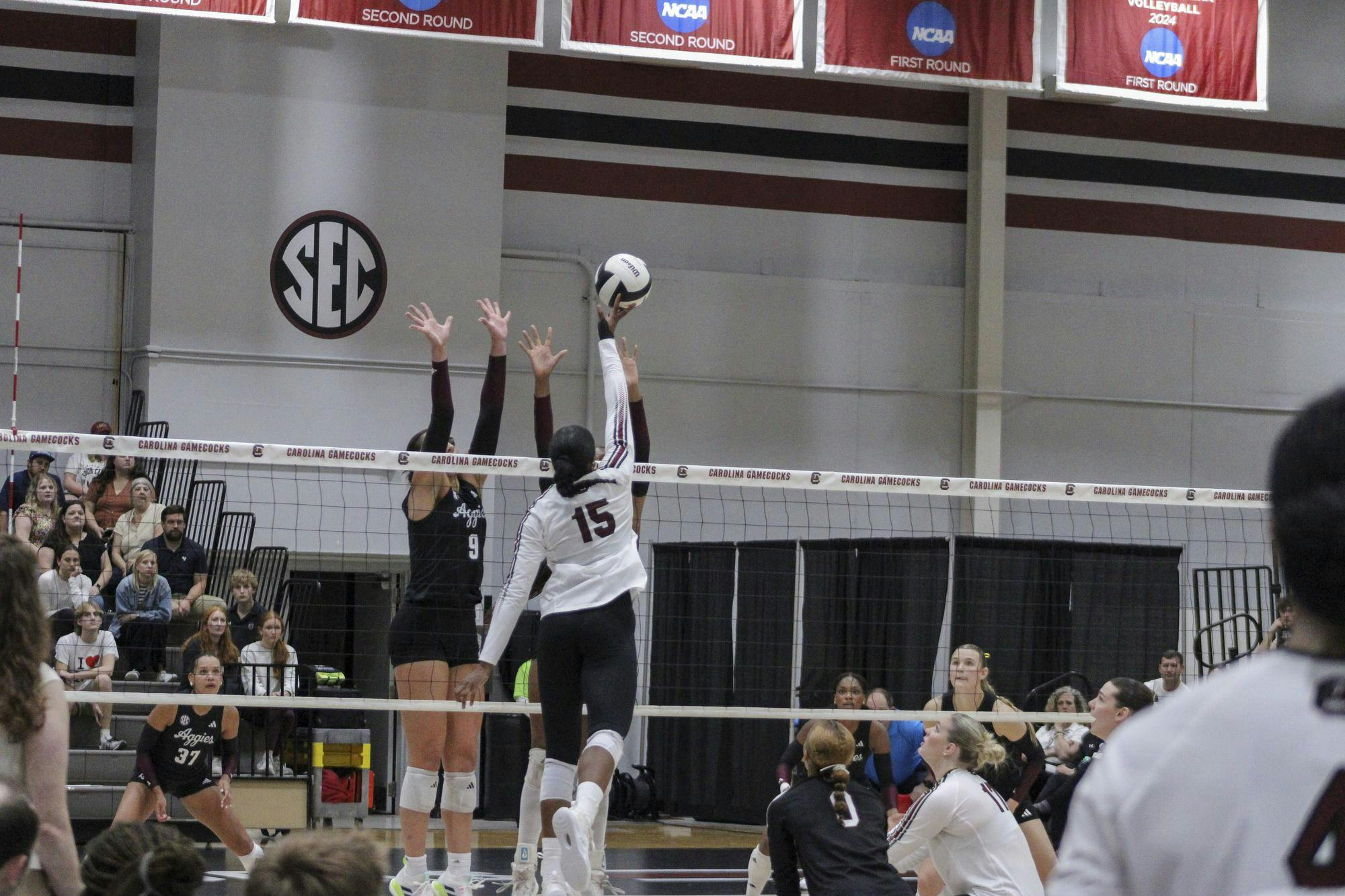 Junior outside hitter Nia Hall tips the ball over the hands of two Texas A&amp;M players on Oct. 1, 2025, at the Carolina Volleyball Center. The Gamecocks lost the match 1-3.