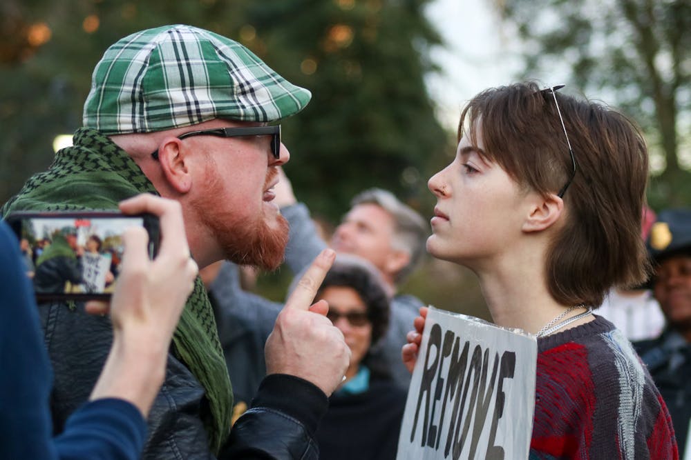 <p>Attendee JT Bessinger (left) and protestor and third-year media arts student Katelynn Basile (right) engage in a verbal altercation with each other at the Statehouse on Jan. 28, 2023. A crowd gathered outside of the Statehouse on Saturday as former President Donald Trump spoke inside to invitees and members of the media.</p>
