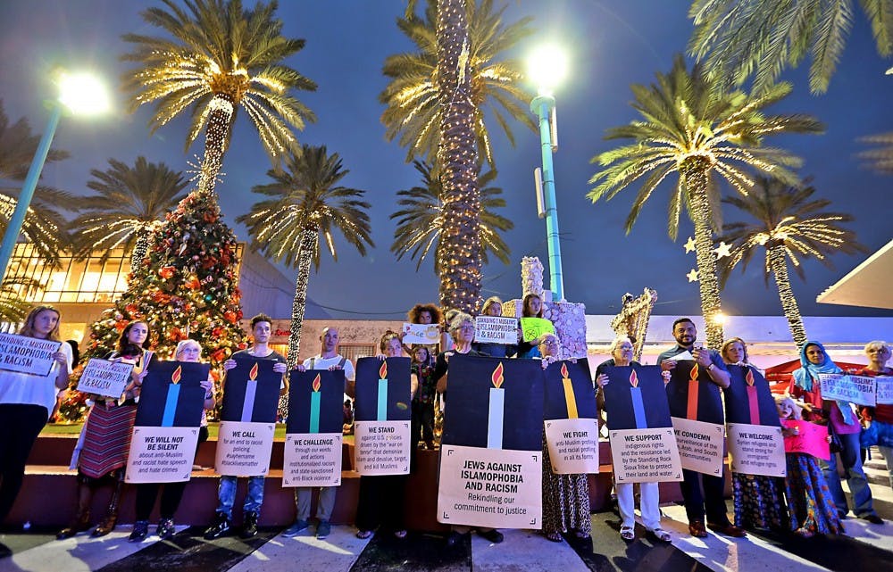 A group gathered on Wednesday, Dec. 21, 2016 on Lincoln Road on Miami Beach in Florida, making a commitment to fighting Islamophobia and racism. (Patrick Farrell/Miami Herald/TNS)