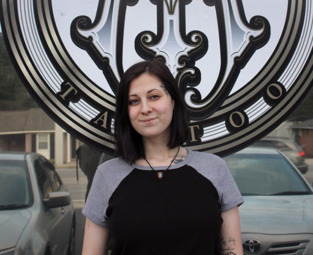 <p>Tattoo artist at Magnetizm Tattoo Heather Belle stands in front of the shop. Magnetizm Tattoo is located at 7345 Parklane Road, Unit C.</p>