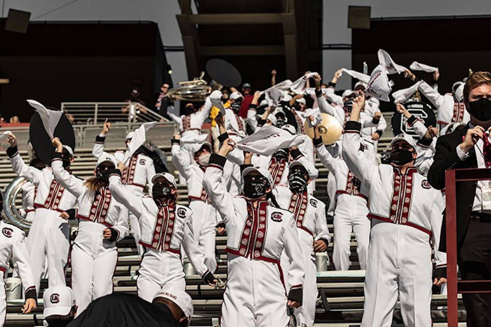 <p>Masked members of the Carolina Band cheer on the Gamecocks. The band has had to make changes in order to stay safe during the COVID-19 pandemic.&nbsp;</p>