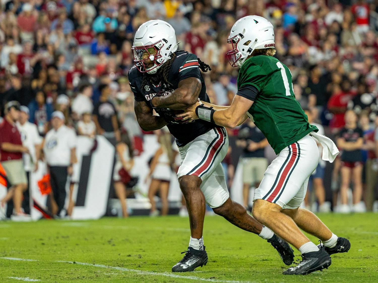 FILE — Freshman quarterback Cutter Woods fakes a handoff to graduate running back Rahsul Faison during the spring football game at Williams-Brice Stadium on April 18, 2025. Faison has been granted an additional year of eligibility from the NCAA, allowing him to play for the Gamecocks this year.