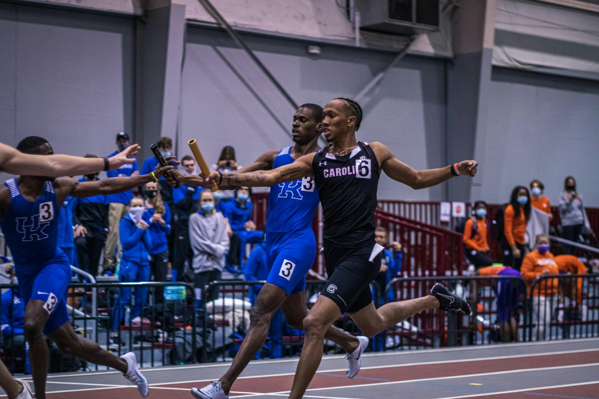 &nbsp;Sophomore EJ Richardson passes the baton to his teammate during a relay race.&nbsp;