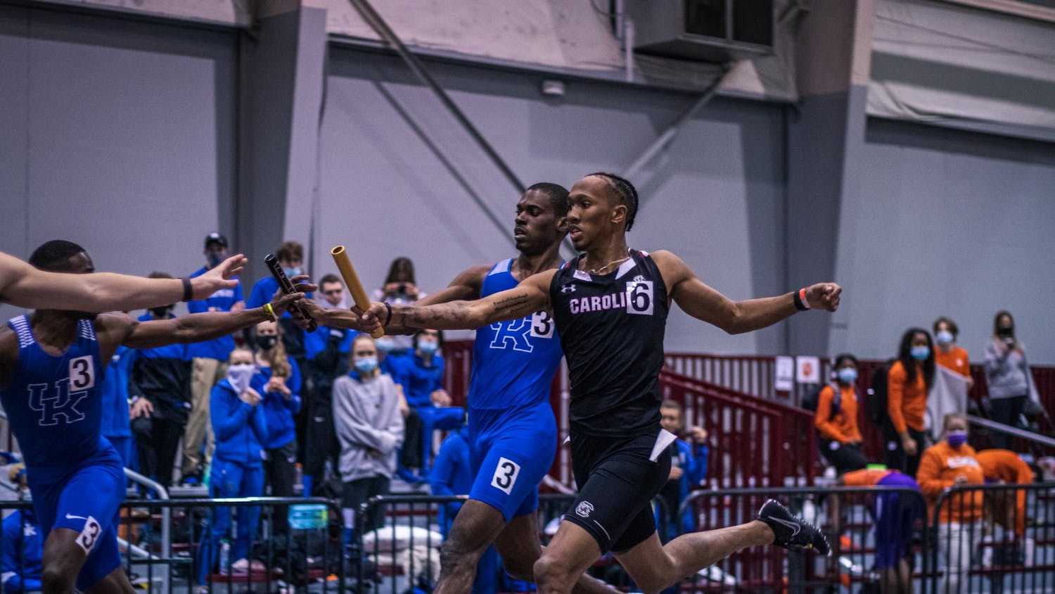 &nbsp;Sophomore EJ Richardson passes the baton to his teammate during a relay race.&nbsp;