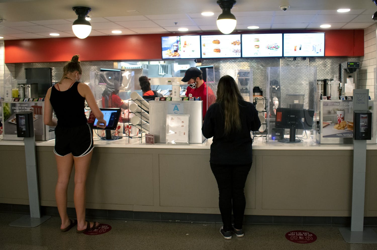 Students order at touch screen monitors at the Chick-fil-A in Russell House.
