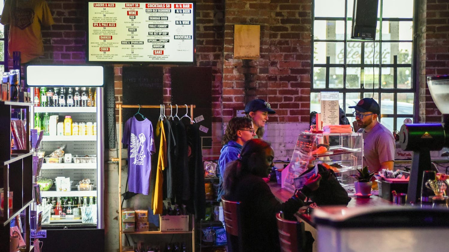 Customers order coffee and other drinks at Curiosity Coffee Bar’s counter just before their Open Mic night on Oct. 15, 2024. This event is one of many hosted by South Carolina Pride as part of Columbia’s greater Famously Hot pride week.