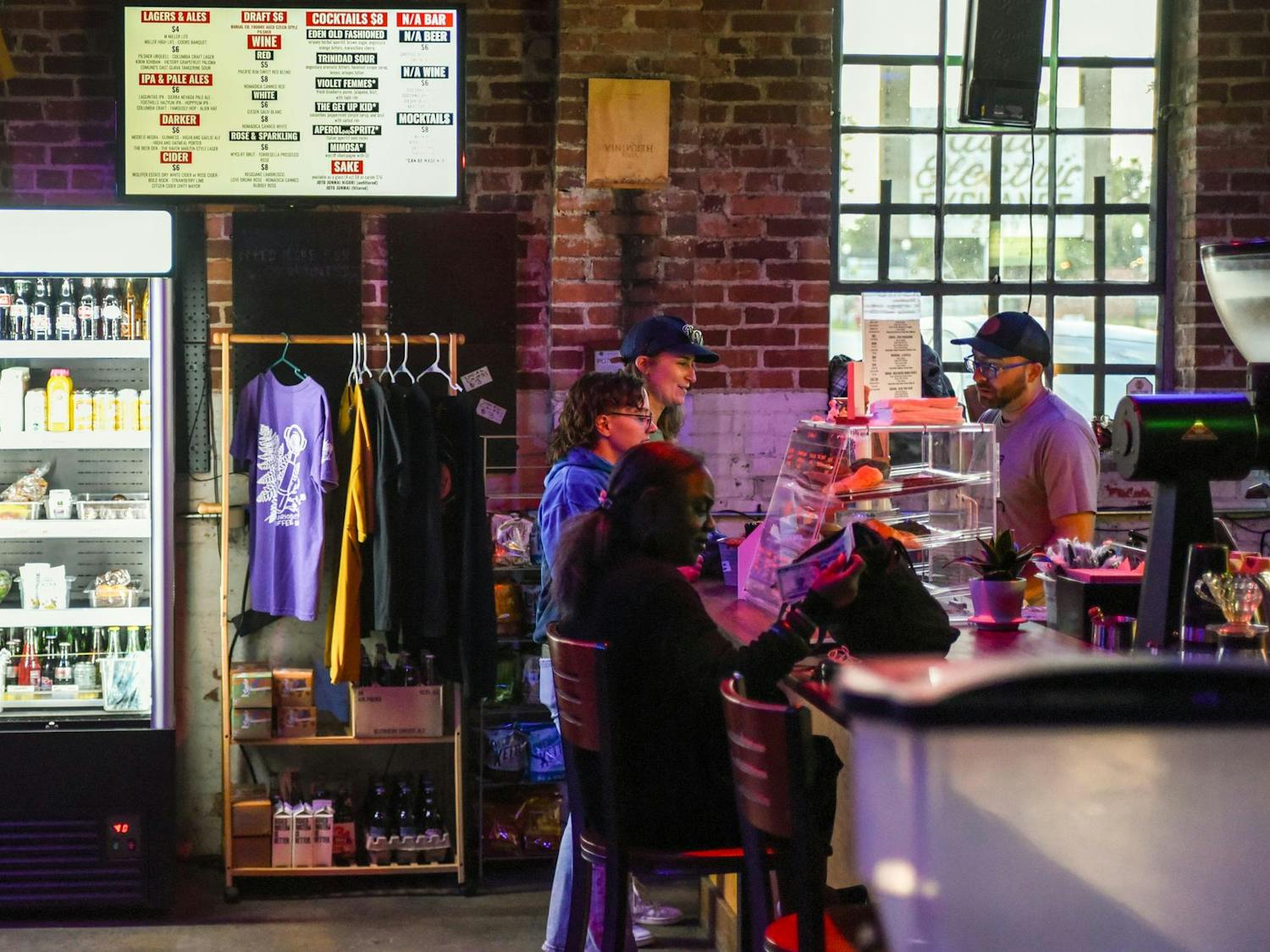 Customers order coffee and other drinks at Curiosity Coffee Bar’s counter just before their Open Mic night on Oct. 15, 2024. This event is one of many hosted by South Carolina Pride as part of Columbia’s greater Famously Hot pride week.