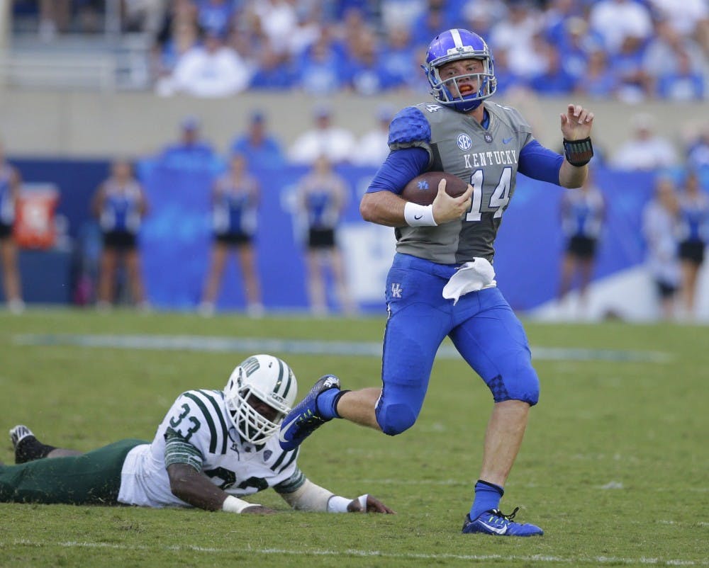 Kentucky quarterback Patrick Towles (14) gets around the end on Ohio linebacker Blair Brown (33) at Commonwealth Stadium in Lexington, Ky., on Saturday, Sept. 6, 2014. Kentucky won, 20-3. (Mark Cornelison/Lexington Herald-Leader/MCT)