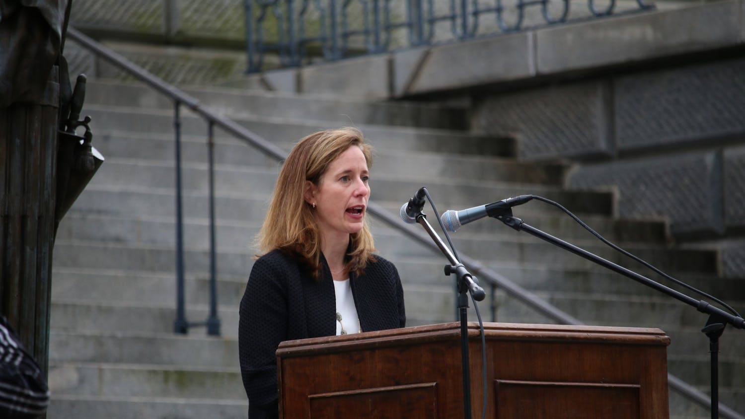 Ann Warner, CEO of Women’s Rights and Empowerment Network (WREN), speaks during Tuesday's protest. WREN was one of the organizations that put together the drive-by “Stop the Ban” protest. 