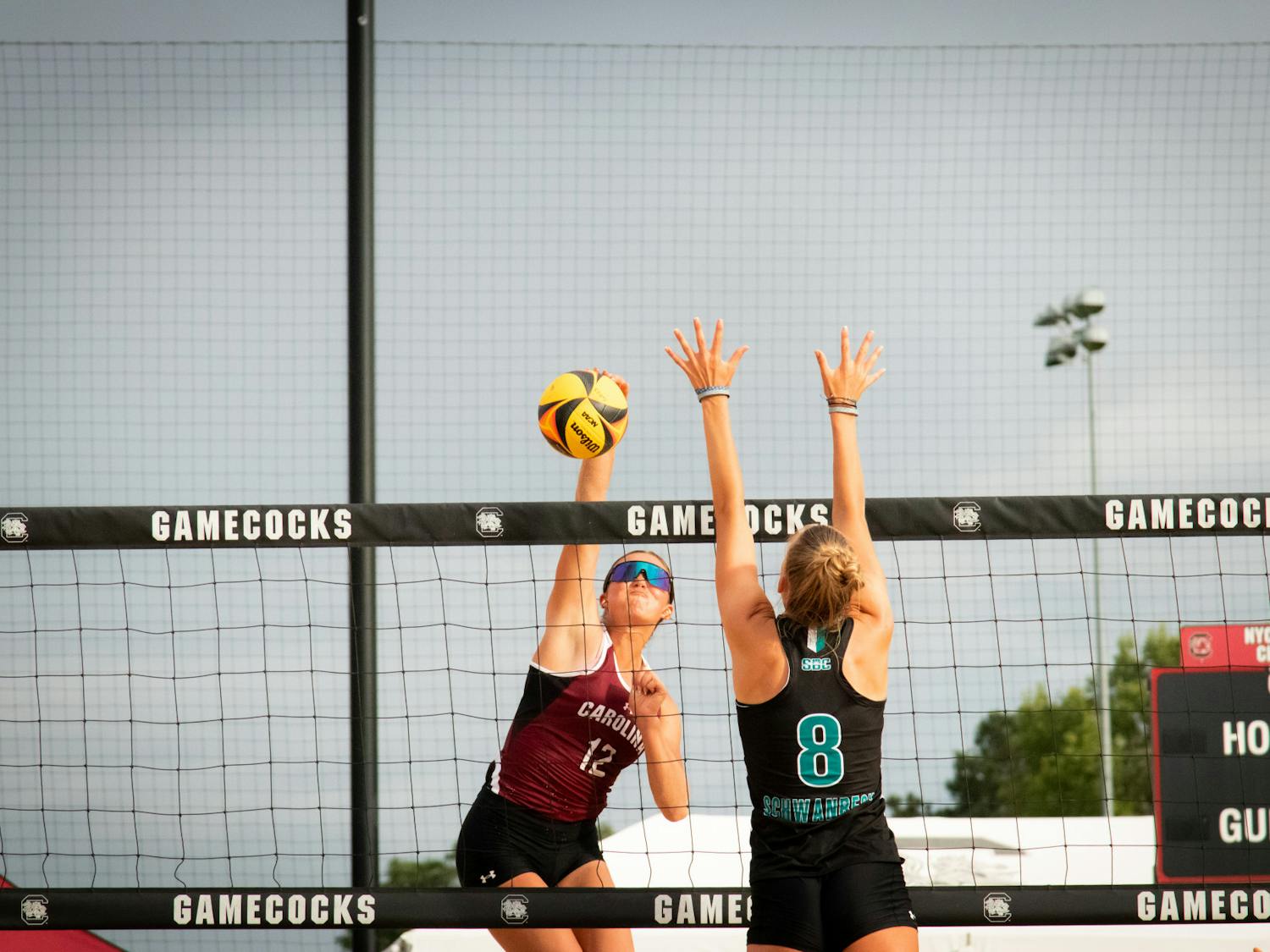 Freshman Morgan Downs strikes the ball while Coastal Carolina players try to block the point. With little success in doing so, Downs and freshman VB Trost were unstoppable, winning their match in two sets, 21-15 and 21-16, on April 14, 2023. &nbsp;&nbsp;