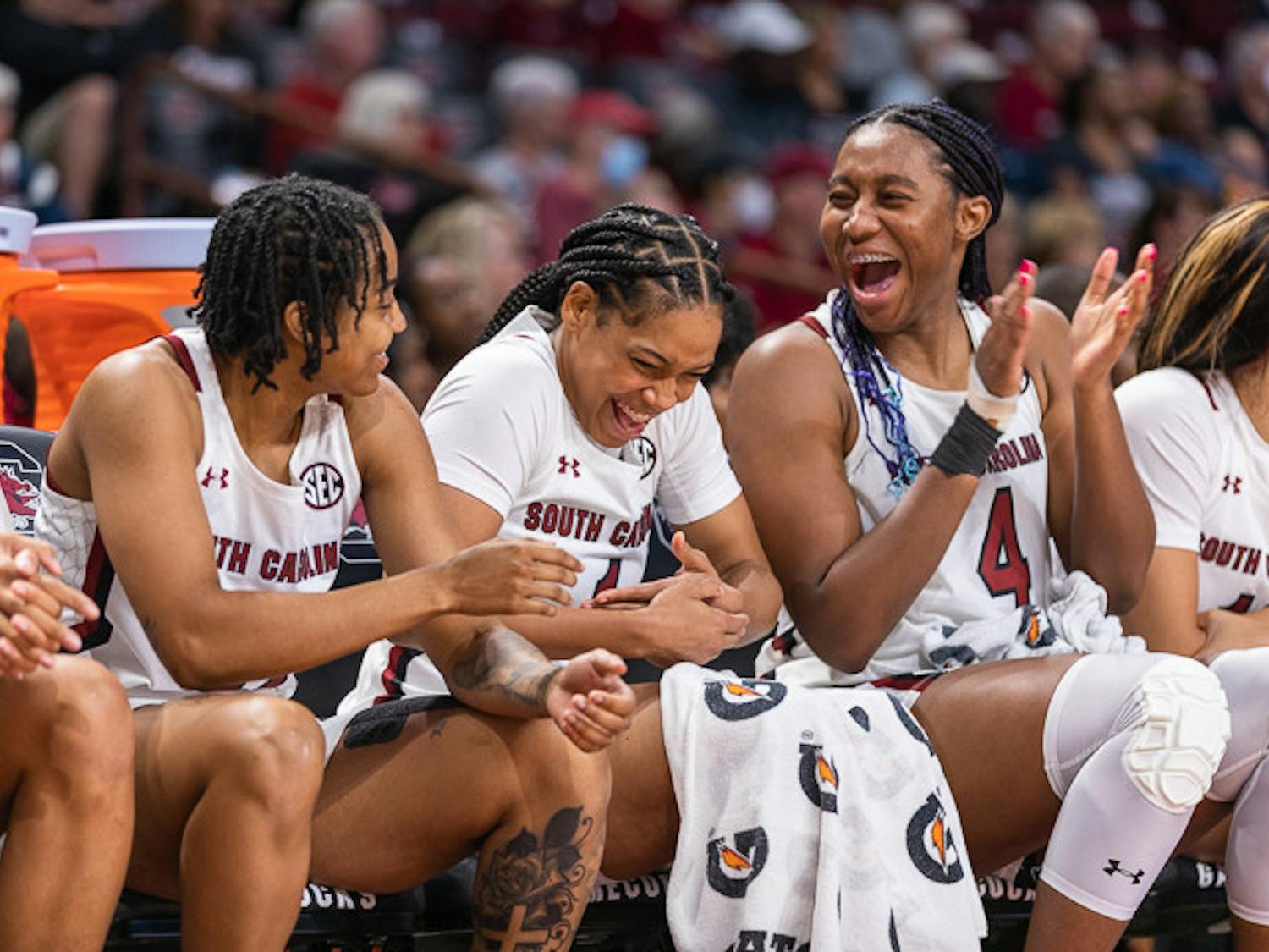 Graduate student guard Kierra Fletcher (left) alongside senior guard Zia Cooke (center) and senior forward Aliyah Boston (on right) laugh on the bench before their first win of the season. South Carolina beat East Tennessee State 101-31 Nov. 7, 2022.&nbsp;
