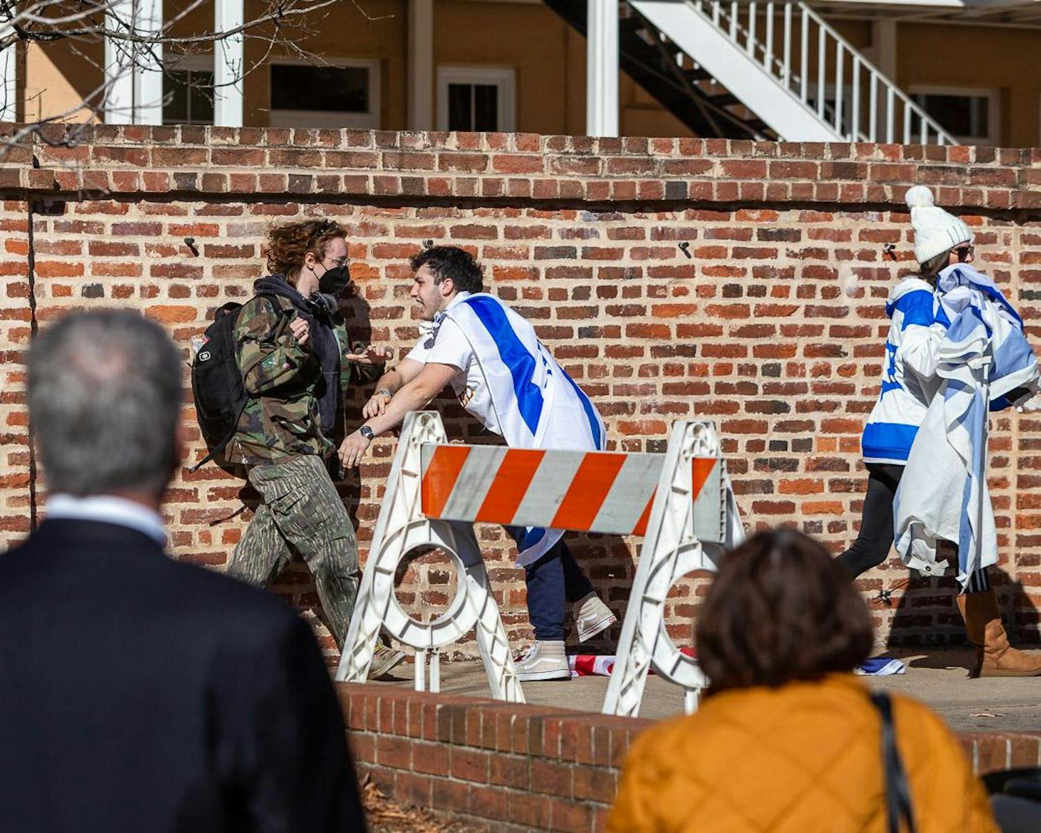 A rally organizer (right) pushes back a counter-protester (left) during the pro-Israel rally on Greene Street on Dec. 7, 2023. The short altercation began after the camouflaged protestor began tearing down Israeli and United States flags hanging up on the wall for the rally while another protestor took the microphone to accuse Israel of committing genocide and call the U.S. complicit.