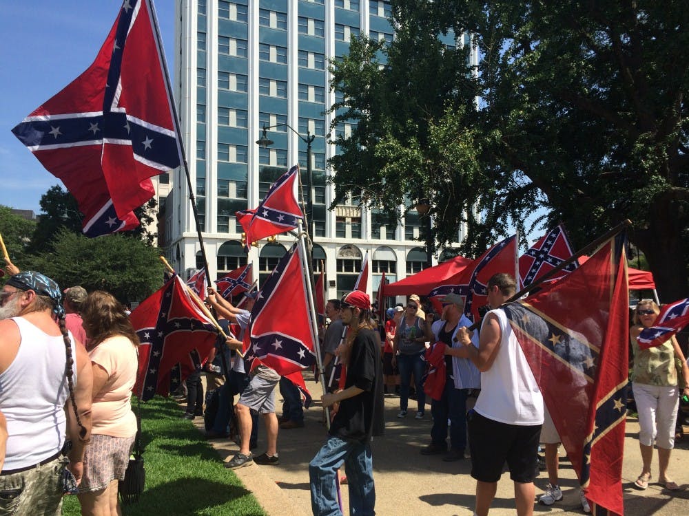 <p>Citizens carry Confederate flags at a rally outside the Statehouse&nbsp;on Sunday, July 10, one year after the flag's removal from Statehouse grounds.</p>