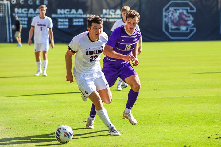 Senior midfielder Parker League looks for a teammate to pass the ball to as a James Madison defender closes in. The Gamecocks tied 1-1 with the Dukes on Oct. 23, 2022.