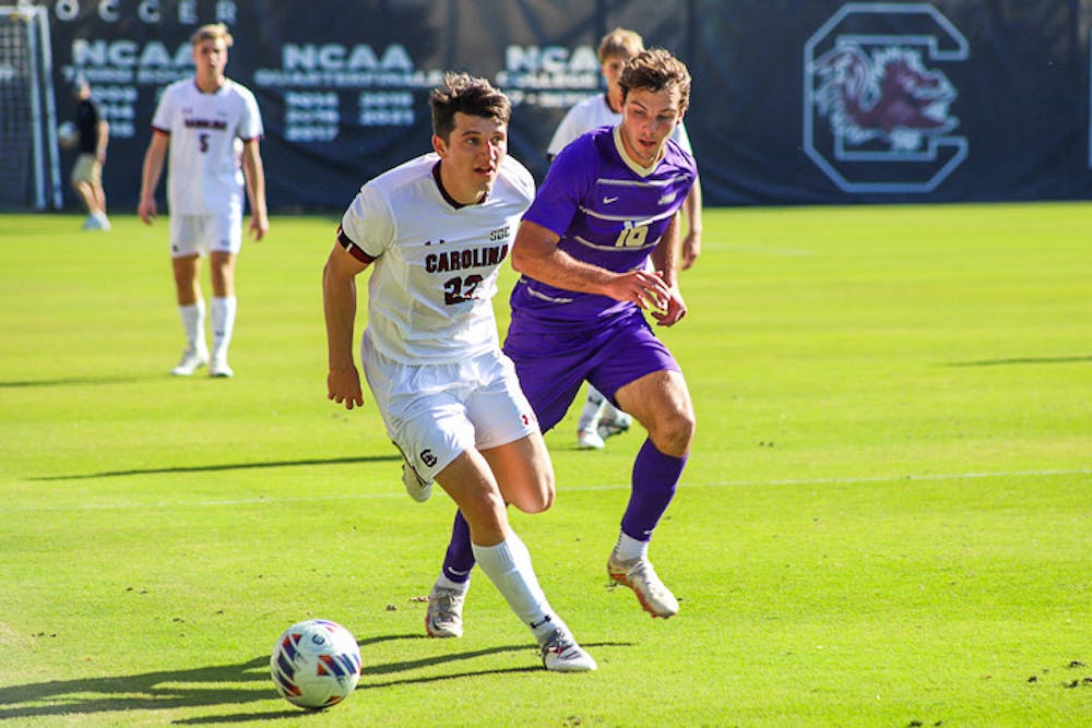 <p>Senior midfielder Parker League looks for a teammate to pass the ball to as a James Madison defender closes in. The Gamecocks tied 1-1 with the Dukes on Oct. 23, 2022.</p>