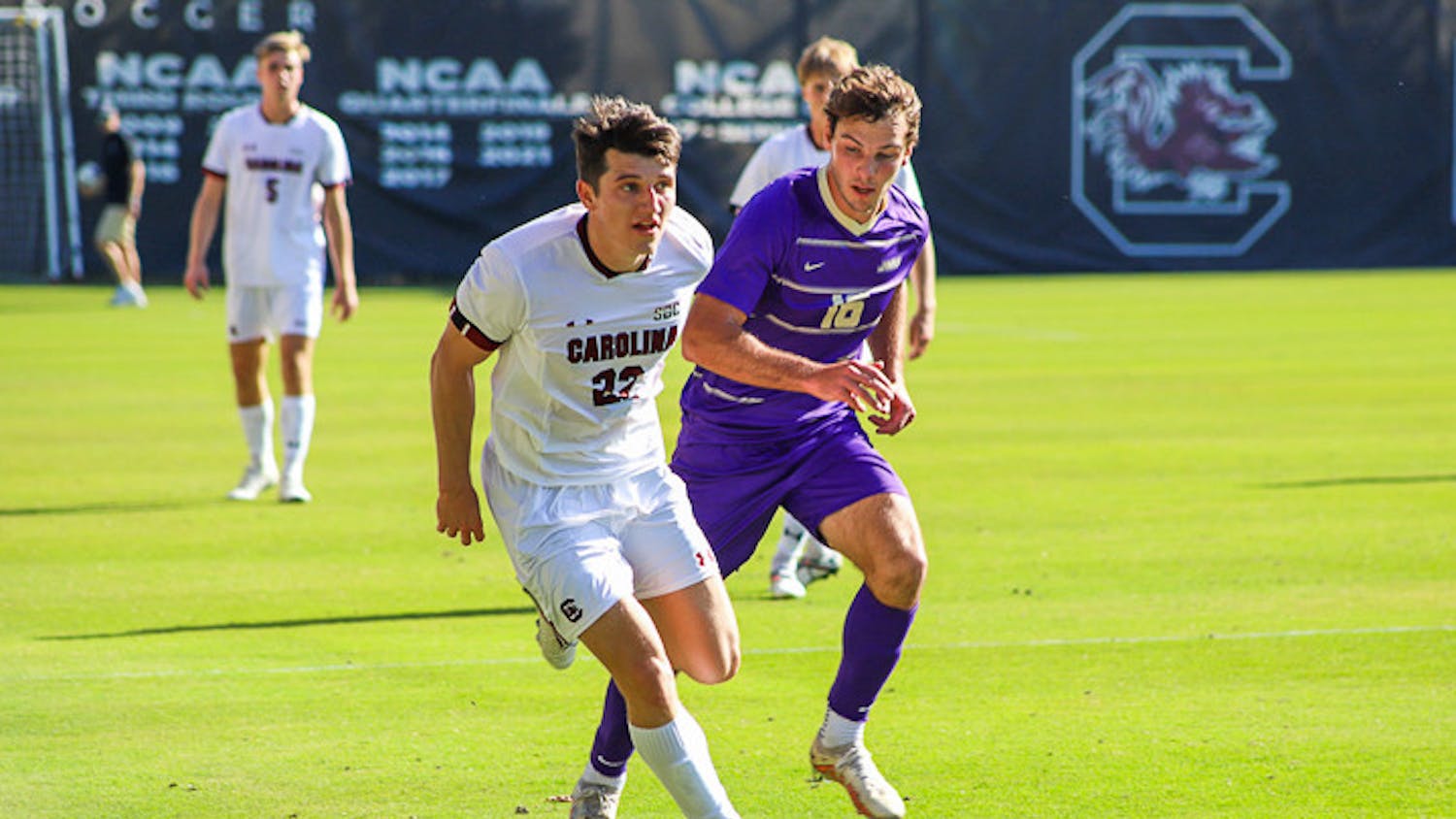 Senior midfielder Parker League looks for a teammate to pass the ball to as a James Madison defender closes in. The Gamecocks tied 1-1 with the Dukes on Oct. 23, 2022.
