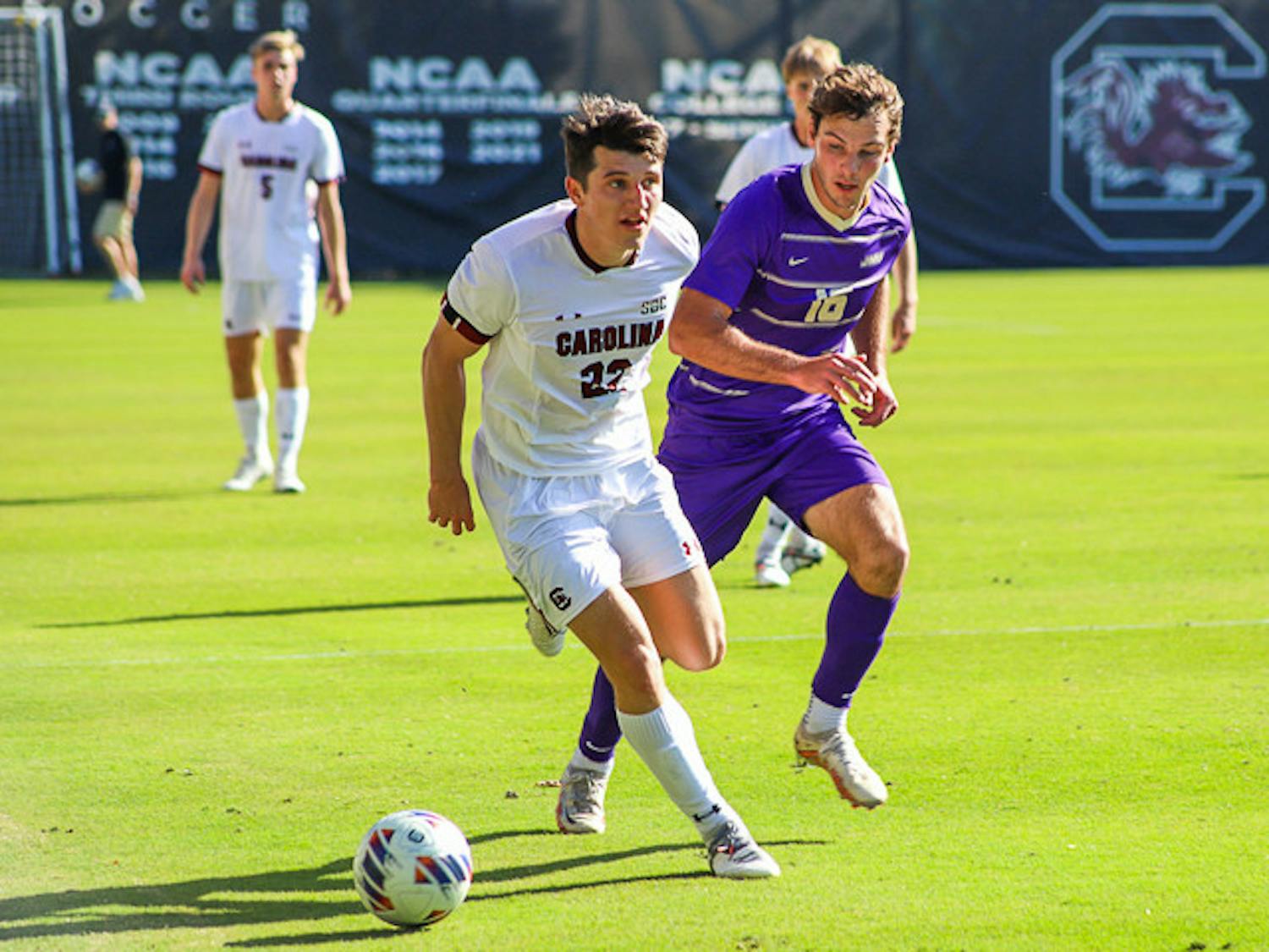 Senior midfielder Parker League looks for a teammate to pass the ball to as a James Madison defender closes in. The Gamecocks tied 1-1 with the Dukes on Oct. 23, 2022.