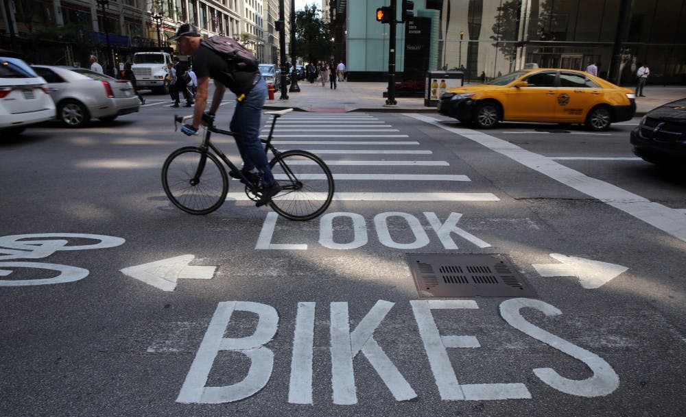 A bicyclist zooms past the "look bikes" signage at Dearborn and Madison in Chicago, Thursday, July 25, 2013. (Antonio Perez/Chicago Tribune/MCT) 
