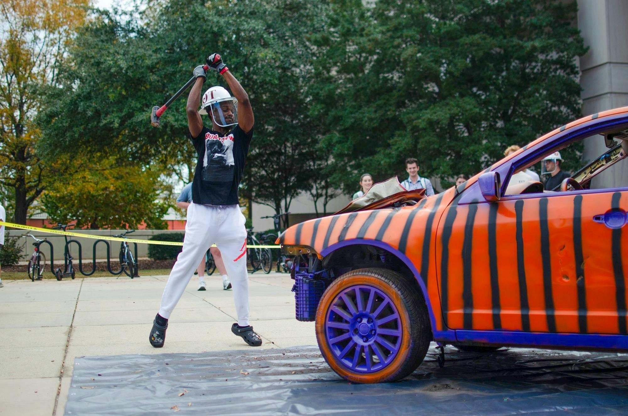 Fourth-year mechanical engineering student Dylon Smith prepares to smash the hood of the Clemson car outside the Swearingen Engineering Center on Nov. 19, 2025. Smith later fully knocked off the hood of the car.