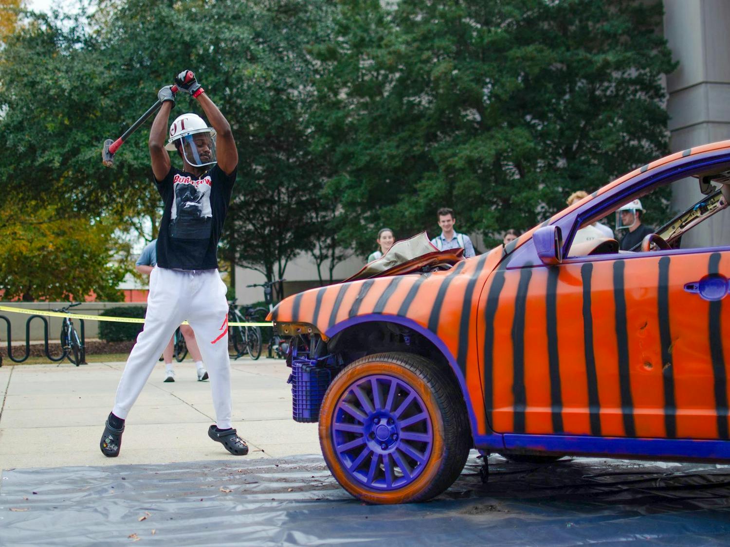 Fourth-year mechanical engineering student Dylon Smith prepares to smash the hood of the Clemson car outside the Swearingen Engineering Center on Nov. 19, 2025. Smith later fully knocked off the hood of the car.