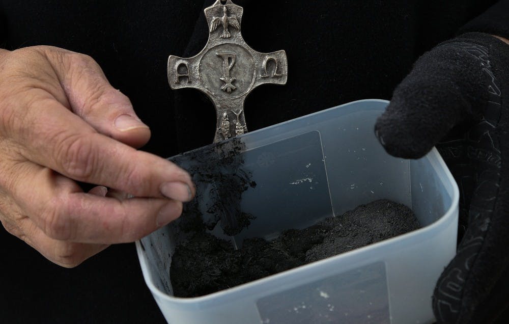 Pastor David Anderson of Greene Street United Methodist Church waits outside the church with palm ashes to offer to students and passersby on March 5, 2014. (Tracy Glantz/The State/MCT)