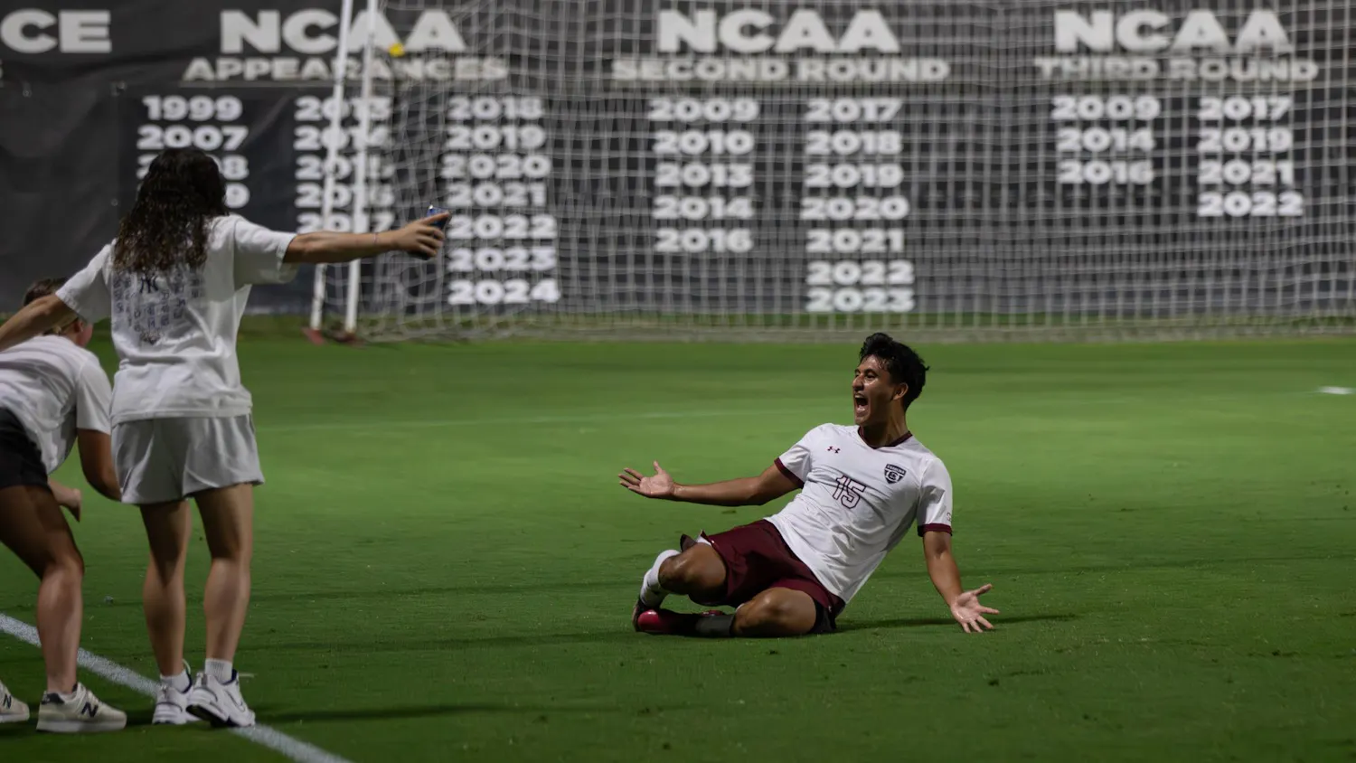 FILE - Sophomore midfielder Alejandro Velazquez-Lopez slides in front of the women’s team to celebrate their win against Queens on Sep. 23, 2025 at Eugene E. Stone III Stadium.