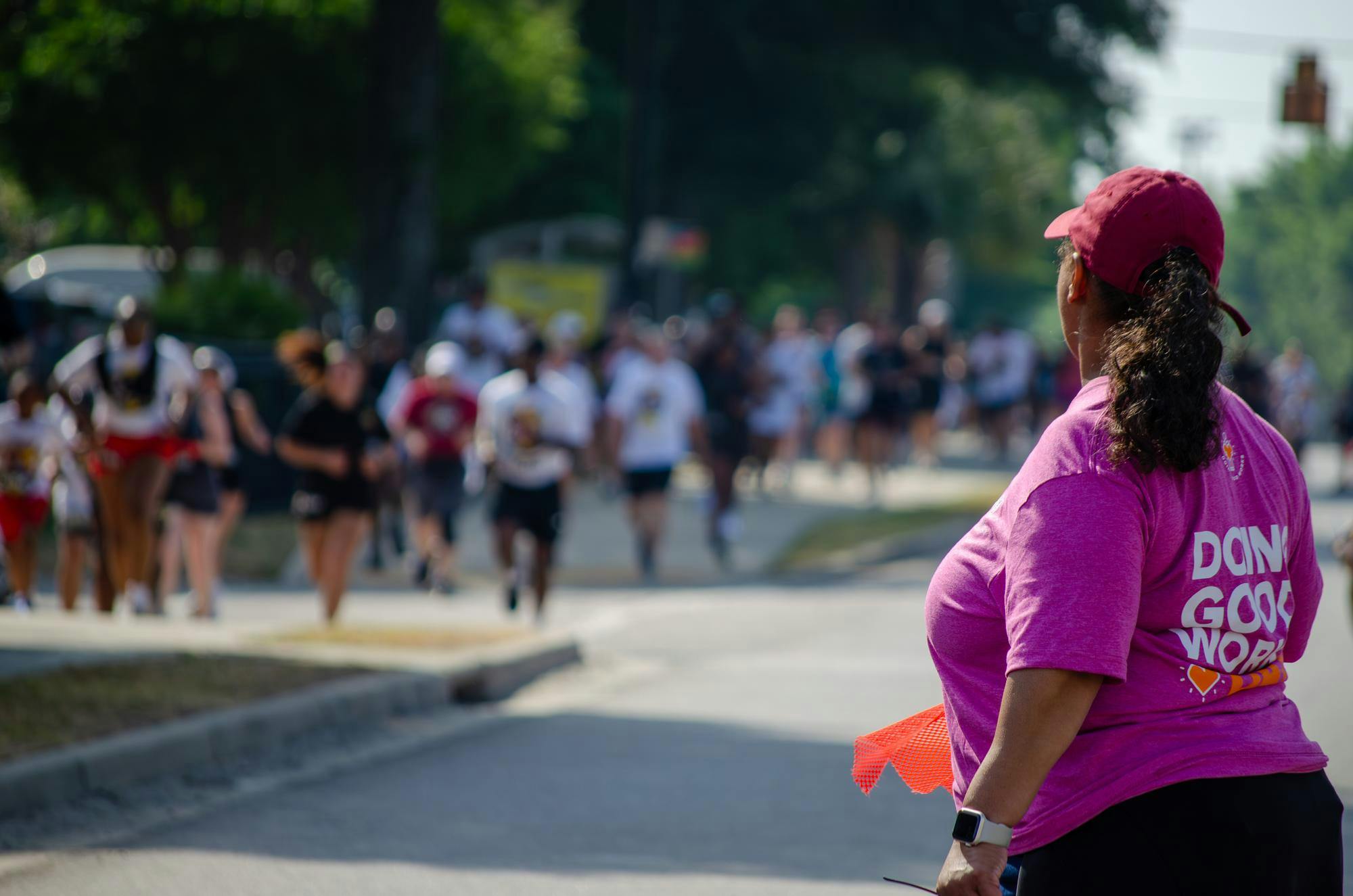 A volunteer watches as runners race to the final turn of the fifth annual Cocky Trot 5K on April 25, 2026. Along with guiding and encouraging runners, volunteers handed out refreshments after the race.