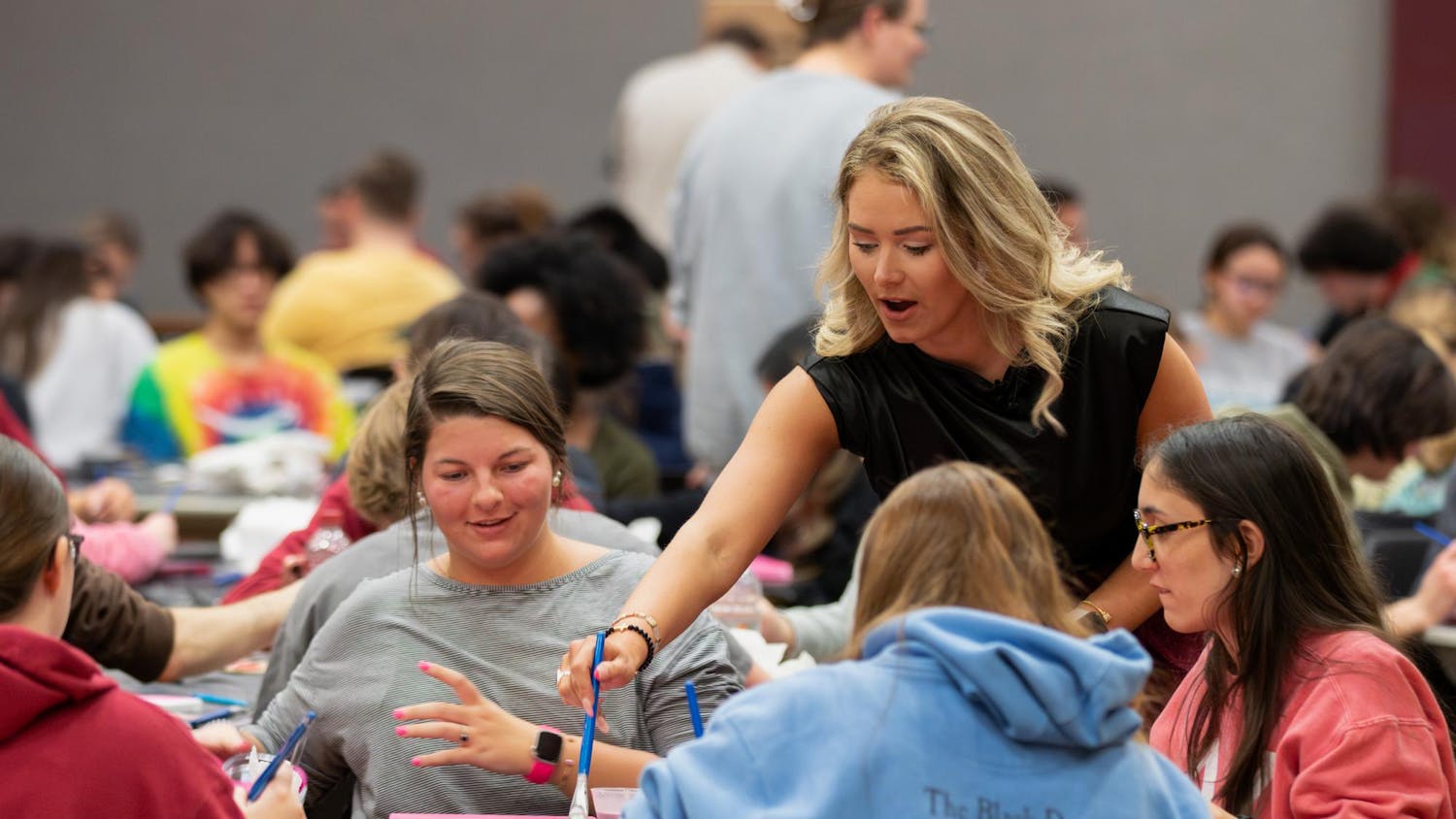 Summer Rogers helps a student during her canvas painting class on Feb. 8, 2024. The free class, hosted by alumna Rodgers, allowed students to create their own USC-themed paintings.