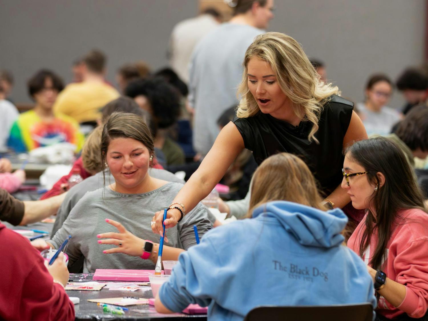 Summer Rogers helps a student during her canvas painting class on Feb. 8, 2024. The free class, hosted by alumna Rodgers, allowed students to create their own USC-themed paintings.