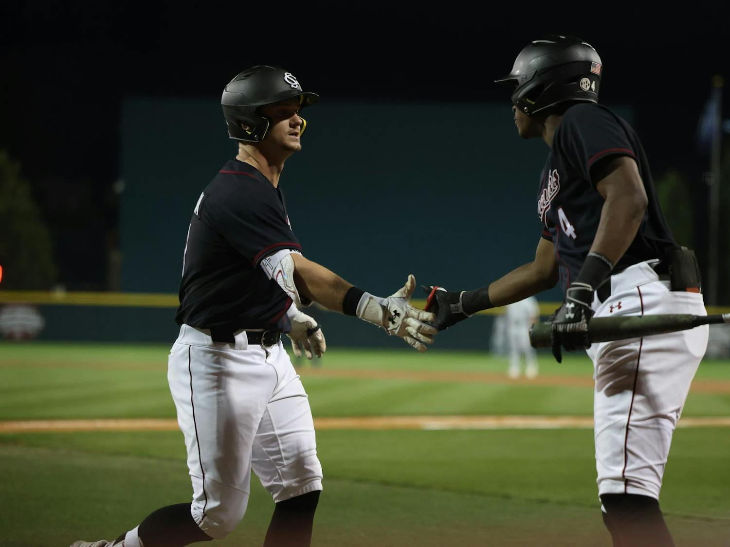 Sophomore infielder Erik Parker congratulates junior outfielder Aaron Jamison at home plate after Jamison launched a home run during South Carolina’s March 4 matchup against Charleston Southern at Founders Park. The Gamecocks won 4-1 against the Buccaneers.