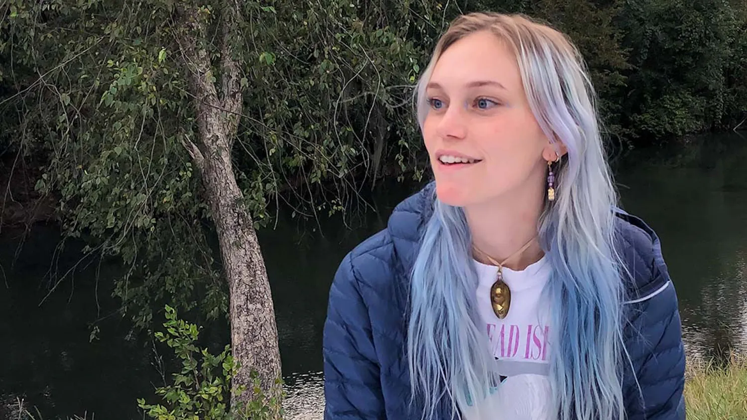 Portrait of University of South Carolina graduate Allison Rogers sitting by a river in Columbia, South Carolina. Rogers strongly influences the arts community in Columbia and helps support and promote other artists in their craft.