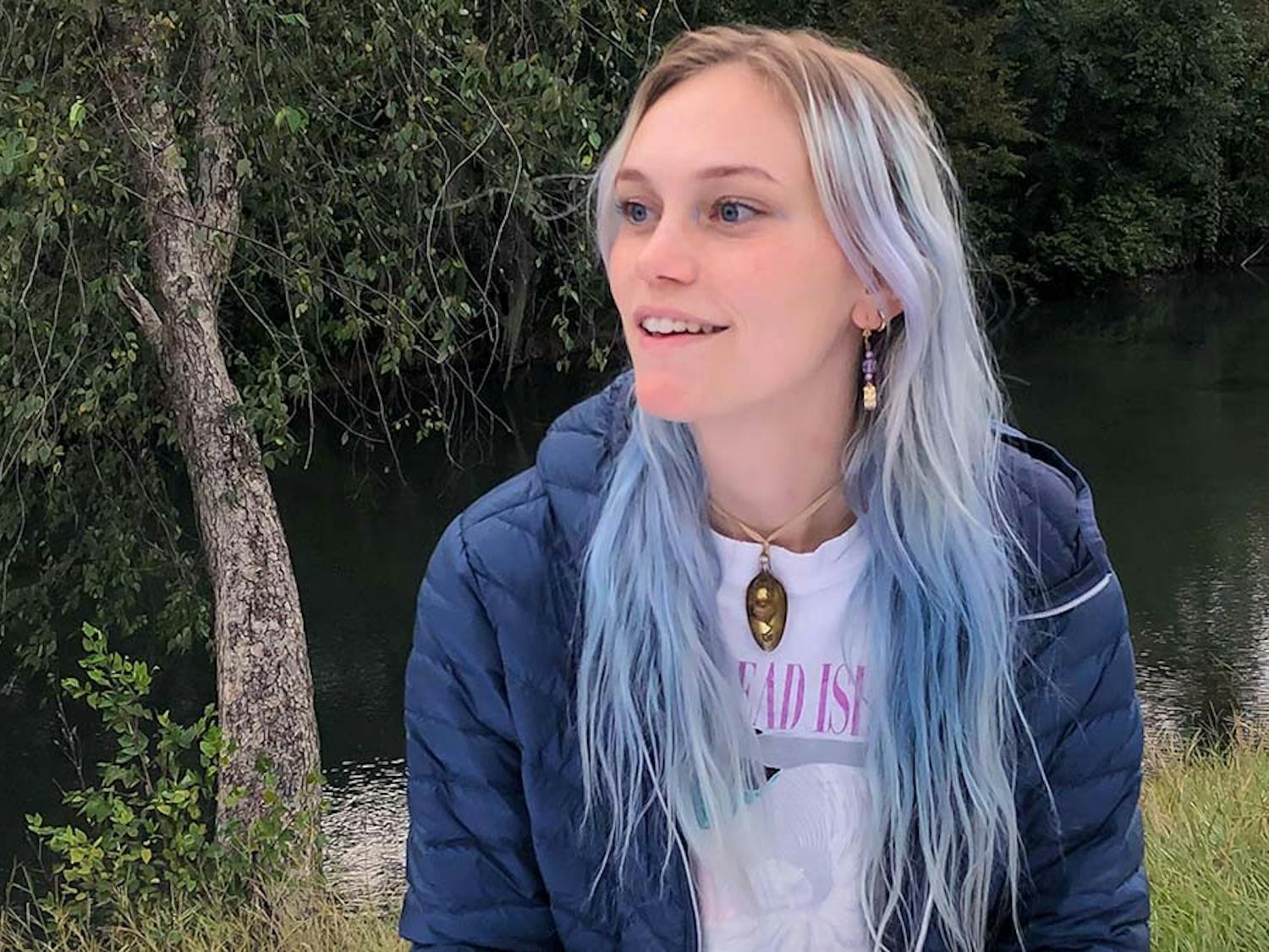 Portrait of University of South Carolina graduate Allison Rogers sitting by a river in Columbia, South Carolina. Rogers strongly influences the arts community in Columbia and helps support and promote other artists in their craft.