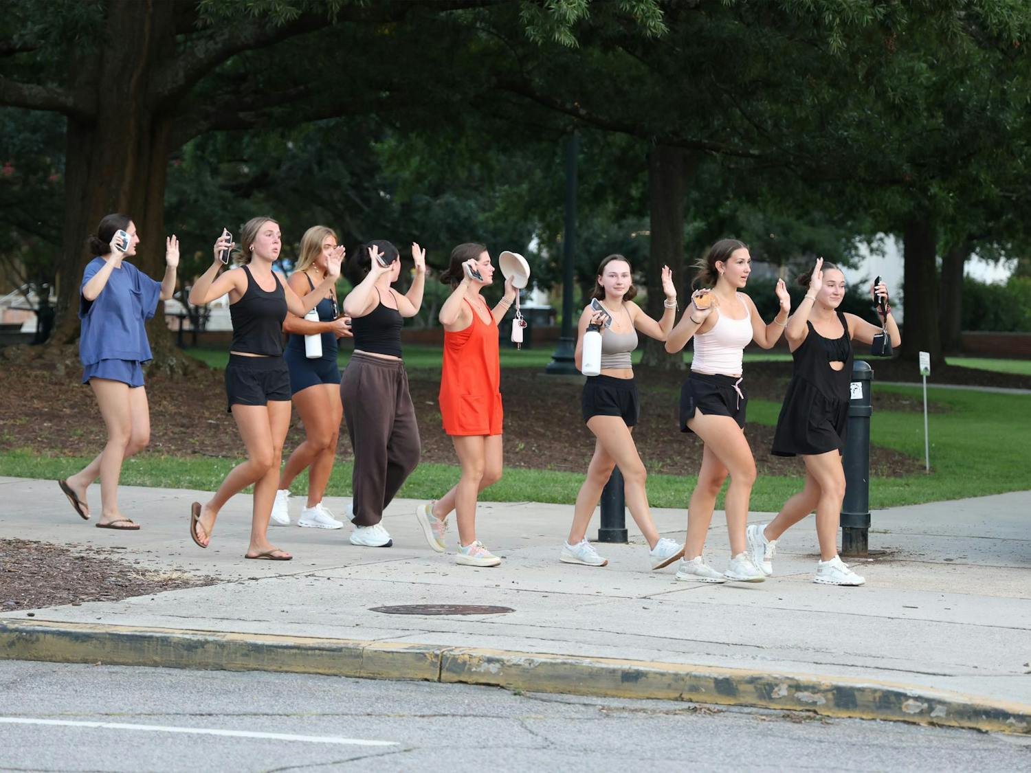 FILE — A group of students hold their hands up while walking away from Russell House during an active shooter alert at Thomas Cooper Library on Aug. 24, 2025. Officials later said there was no evidence of a shooter.
