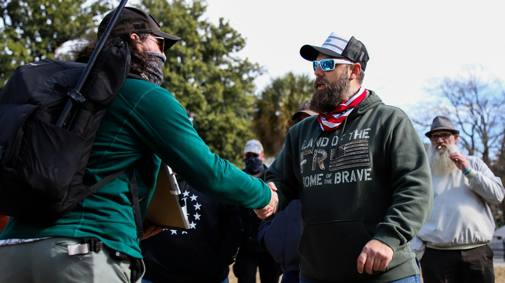 Shawn Laurie of the “Drive4America” caravan shakes the hand of one of the counter-protesters. Many protesters shook hands after a discussion.&nbsp;