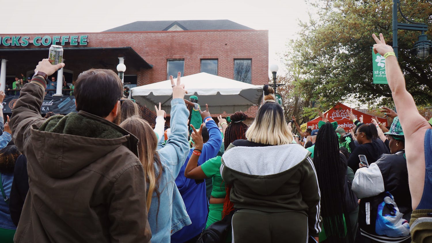Columbia musician DJ VooDoo Child asks the crowd to hold up peace signs to acknowledge the need for peace and gathering as a community. Five Points held its annual St. Patrick’s Day event on March 18, 2023.&nbsp;