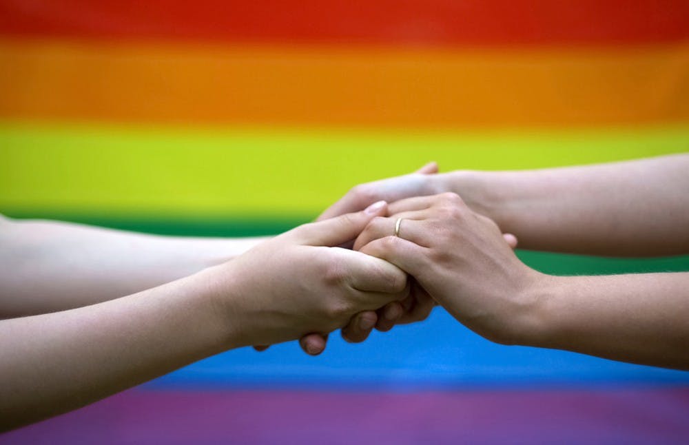 Gay wedding, rainbow flag on background, same-sex marriage, minority rights