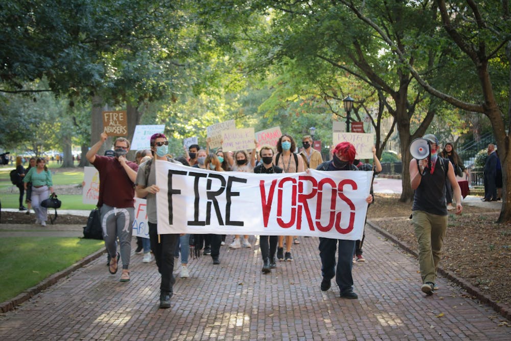 <p>Protestors walk down the Horseshoe holding a sign that reads, 'FIRE VOROS.' USC students, faculty and staff protest the university's handling of the sexual assault allegations against professor David Voros and other alleged abusers.&nbsp;</p>