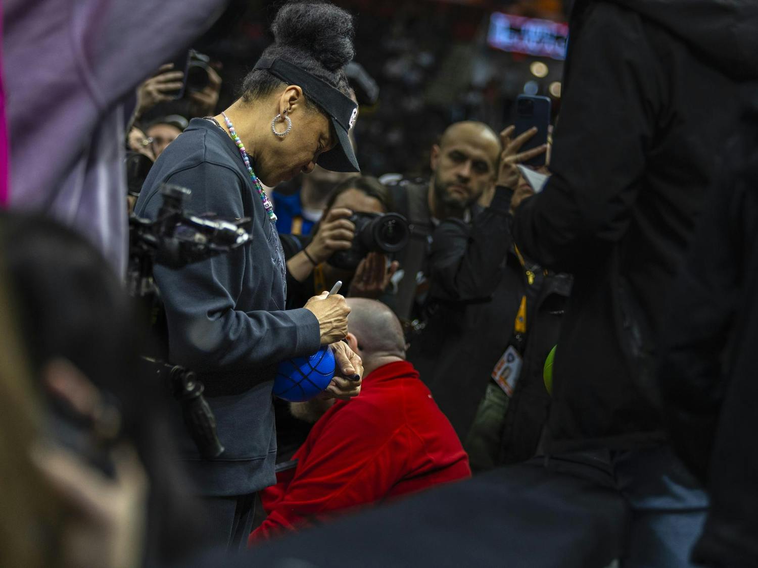 Gamecock women’s basketball head coach Dawn Staley signs a fan's basketball during open practice on April 6, 2024. Staley spent part of the practice greeting fans, signing items and taking selfies with members of the audience.